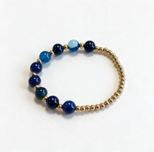 Dames armband Bandagaat 8 mm met RVS goudkleurige kralen